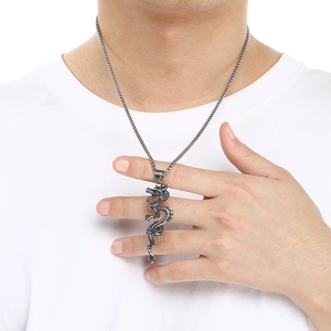 Detailopname van een vintage roestvrijstalen draakhanger ketting bij een man