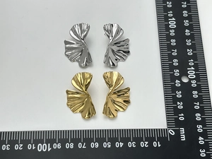 Detailed top view of 18K gold and silver ginkgo leaf earrings with measuring scale