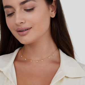 Close-up of 18K gold plated titanium necklace with small white pearls on a female model