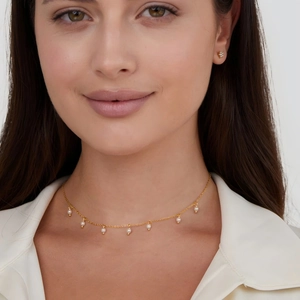 Detail of 18K gold-plated titanium necklace with white seed pearls on female model