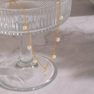 Macro detail of elegant 18K gold plated chain necklace with delicate white pearls