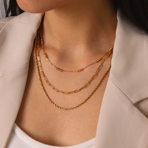 Detail view of 18k gold plated stainless steel triple layered necklace on model