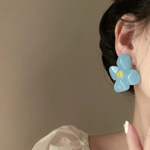Detailed view of French vintage blue acrylic flower earrings with oversized design