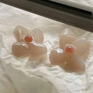 Macro detail of French retro acrylic flower earrings in Thai tea jelly color