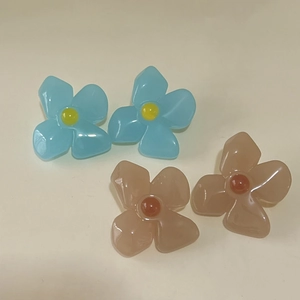 Detail view showing blue and coffee brown acrylic flower earrings with vintage French style