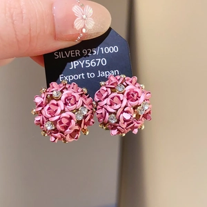 Pink rose floral stud earrings with rhinestones on a black display card