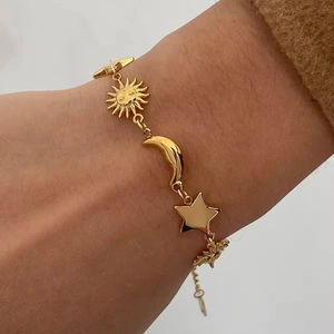 Detail of 18K gold-plated stainless steel bracelet featuring sun moon and star charms