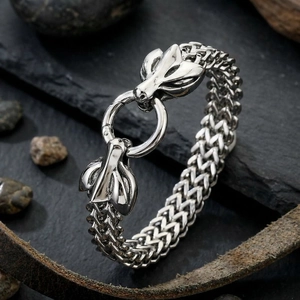 Macro detail of men's stainless steel dragon head bracelet with woven mesh chain