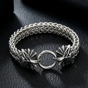 Detailed close-up of viking style wolf head carving on steel braided bracelet