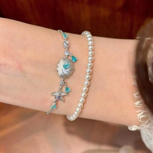 Elegantes Muschel- und Seestern-Armband mit blauen Tropfensteinen und Perlenstrang