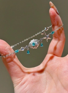 Exquisite silver bracelet with ocean-themed starfish and teardrop blue zircon charms