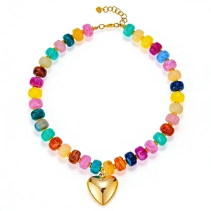 Vista dettagliata della collana di perle in resina colorata con ciondolo a cuore d'oro.