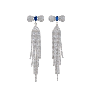 Silver bow tassel earrings with blue stones and sparkling diamond accents