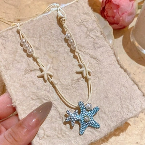 Handmade blue starfish necklace with pearls and conch shells for summer beach vacations