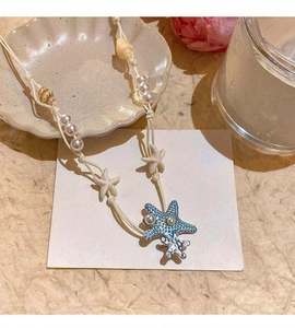 Detailed view of a beach-style necklace featuring a blue starfish pendant and shell beads.
