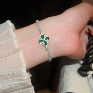 Nahaufnahme eines eleganten funkelnden Zirkon-Vierklee-Armbands in Grün