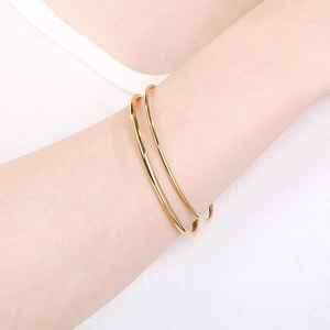 Minimalist gold stainless steel round wire bangle bracelet for women in a sleek design