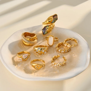 Detailed view of gold-plated stainless steel rings with zircon and cat's eye stones.