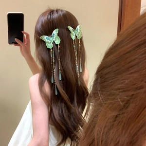 Detailed view of forest-style knitted butterfly hair clips with pearl waterdrop tassels