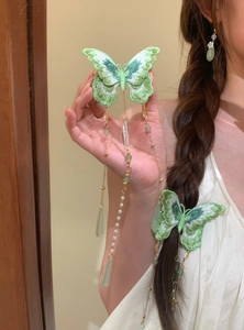Detailed view of green butterfly hair clip with elegant pearl and drop tassels