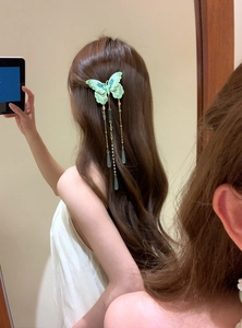 Close-up of a sweet green knit butterfly hair clip with pearl and waterdrop tassels