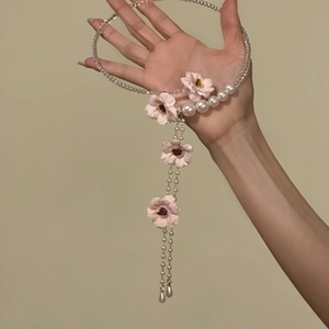 Dettaglio di un girocollo vintage con perle, perline di vetro e nappe floreali in mano