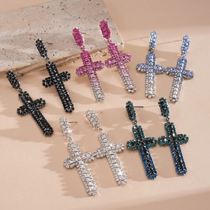 Gros plan détaillé de boucles d'oreilles pendantes en croix avec strass colorés