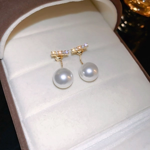Elegant French style gold stud earrings featuring a crystal bar and white pearl drops