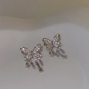 Close-up of elegant silver butterfly tassel ear bone clips with sparkling rhinestones