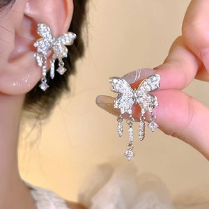 Close-up view of a sparkling crystal butterfly ear cuff with elegant dangling tassel details