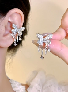 Detail view of butterfly tassel ear cuff with sparkling stones on a woman's ear