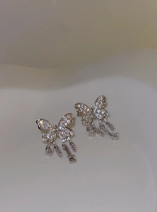 Detailed view of silver butterfly ear cuffs with sparkling crystal tassels