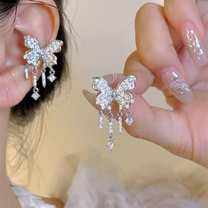 Detailed view of a sparkling butterfly ear cuff with dangling crystal tassels for women.