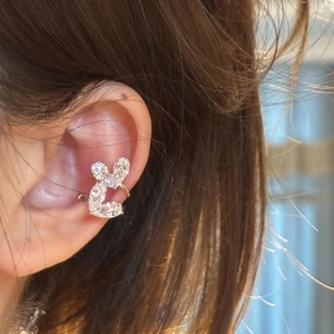 Primo piano di un ear cuff con doppio cuore in zircone per orecchie non forate