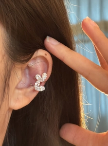 Dettaglio di un elegante ear cuff a doppio cuore in zircone per orecchie senza buco metallo