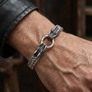 Detailed close-up of a men's double dragon head link bracelet with retro woven chain style