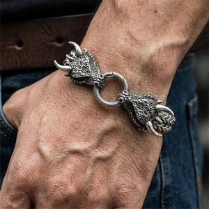 Dettaglio della fibbia a testa di drago retrò su bracciale intrecciato in acciaio