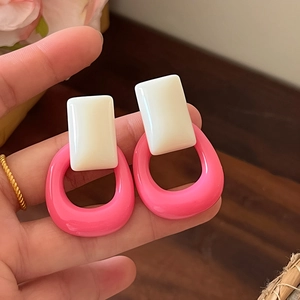 Primer plano de pendientes geométricos de resina rosa y blanco de estilo retro francés