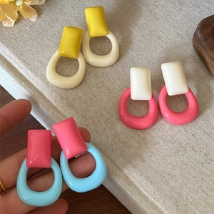 Primer plano macro de pendientes geométricos de resina de colores estilo vintage francés