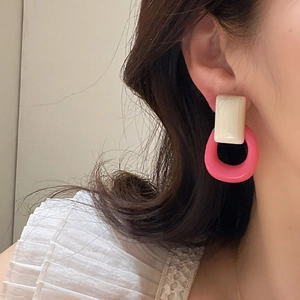 Primer plano de pendientes geométricos de resina retro francesa en rosa y marfil
