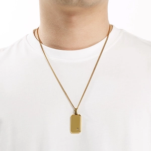 Detalle de un collar con colgante rectangular dorado minimalista con un pequeño diamante