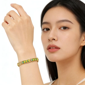 18K gold plated stainless steel bangle featuring yellow and green beads on female wrist