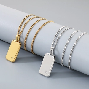Primer plano de colgantes de placa militar minimalistas en acero dorado y plateado