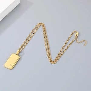Detalle de un colgante de placa militar de acero dorado con un pequeño diamante incrustado