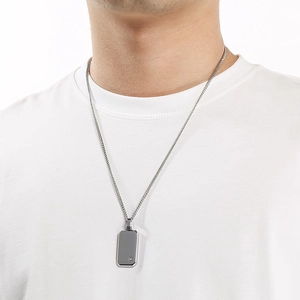 Primer plano de collar con colgante de placa militar de acero inoxidable para hombre