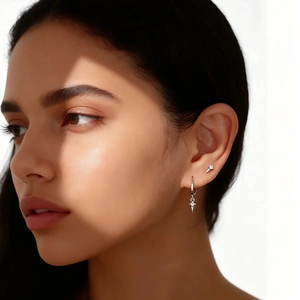 Macro view of S925 silver stud earrings with diamond accents and geometric drop on the ear