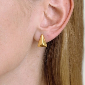 Boucles d'oreilles triangulaires géométriques minimalistes dorées portées sur l'oreille