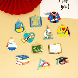Vista detallada de dijes de esmalte con temas educativos para accesorios de bolsos DIY