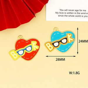 Detalle de colgantes de esmalte de libro en forma de corazón con gafas para mochilas