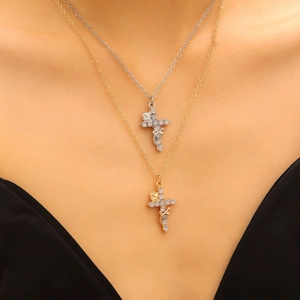 Close-up of gold and silver cross necklaces with roses and zircons on a female model